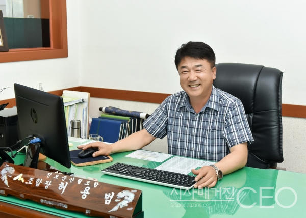 진도군산림조합 허용범 조합장이 잡지에 실을 사진을 촬영하기 위해 책상에 앉아 자연스럽게 웃고 있다. 사진촬영=시사매거진CEO 이 신 기자